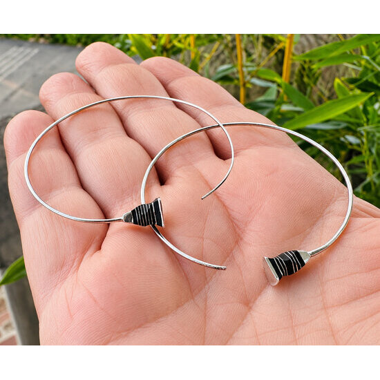 Grandes cr�oles en argent et �b�ne � Diam�tre 5 cm, pr�sent�es en main